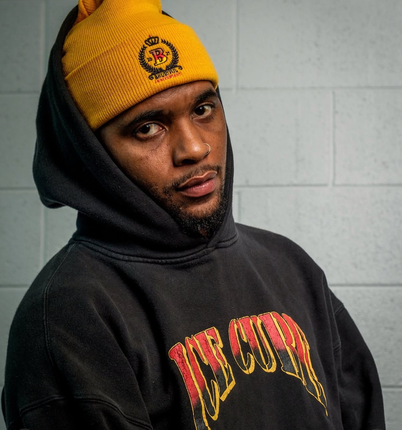 Performer in a yellow beanie and black hoodie